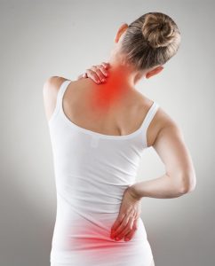 Blick auf die Rückansicht einer Frau, die deutlich sichtbar unter Rückenschmerzen leidet